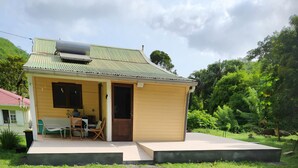 Ein kleines Haus mit Veranda, Tisch und Stühlen.
