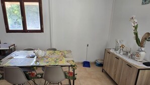 Ein Essbereich mit Tisch für zwei Personen, einer Couch und einer Kommode mit Dekorationsgegenständen.