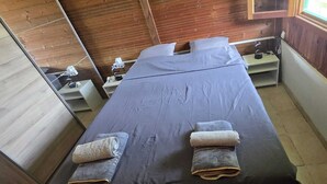 Ein Zimmer mit einem Bett, einem kleinen Tisch und einem Fenster.