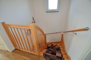 A wooden staircase with a handrail and a window above. - High-quality, tastefully furnished with a fireplace, sleeps up to 4, Wi-Fi, washing machine (Breege)