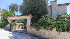 A stone wall with a gate, a pergola, and a sign reading 'Villa Tavla'. - Villa Tavla (KAŞ)