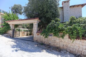A stone wall with a gate, a pergola, and a sign reading 'Villa Tavla'. - Villa Tavla (KAŞ)