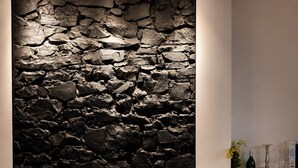 A buffet setup with a stone wall backdrop, various food items, and a wine bottle. - The Green O (Oni)