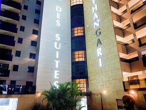 A hotel with illuminated signage reading 'DES SUITES' and 'ANGARI.' - Charming 1-bedroom apartment in vibrant Nairobi for your stay (Nairobi)