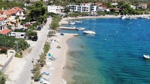 A coastal town with a beach, clear blue waters, and buildings along the shore. - Apartments Vala (Grebaštica)