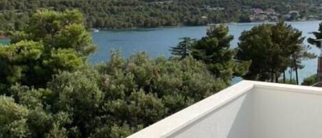 A balcony with a view of a lake and hills.