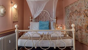 A bed with a canopy, a wall-mounted lamp, a decorative wall hanging, and a radiator. - Familiar Penthouse - Sweet Dreams in Florence (Firenze)