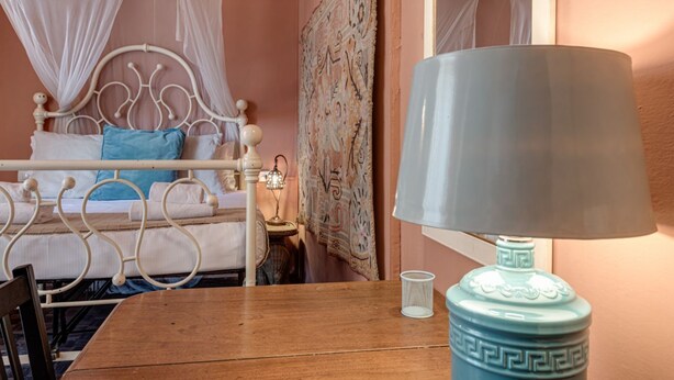 A room with a bed, a table, a lamp, and a wall tapestry. - Familiar Penthouse - Sweet Dreams in Florence (Firenze)
