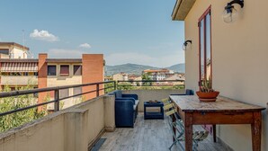 A balcony with outdoor furniture, a table, and a potted plant. - Familiar Penthouse - Sweet Dreams in Florence (Firenze)