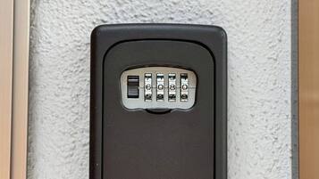 A keypad lock on a textured wall, likely for a door or gate.