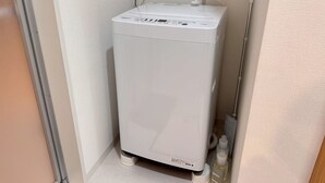 A compact, white, wall-mounted water heater in a corner of a room with a door and a towel rack. - About a 10-minute walk from Okayama Station / Accommodates up to 6 guests / 1 private parking space available / 3 bedrooms (Okayama City)