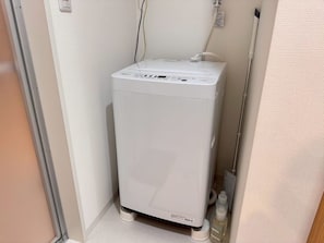 A compact, white, wall-mounted water heater in a corner of a room with a door and a towel rack. - About a 10-minute walk from Okayama Station / Accommodates up to 6 guests / 1 private parking space available / 3 bedrooms (Okayama City)