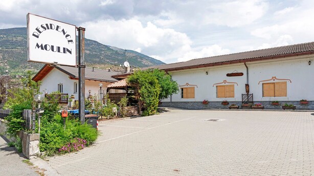 A building with a sign reading 'RESIDENCE MOULIN' and a paved courtyard.