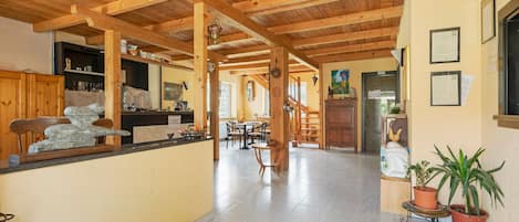 Una cocina espaciosa con vigas de madera, una escultura de piedra y un comedor con sillas y una mesa.