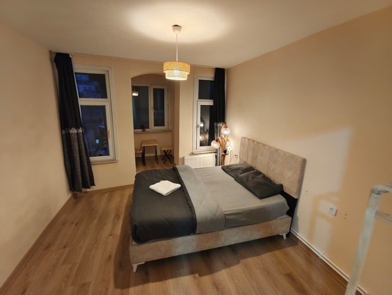 Une chambre à coucher avec un lit, une fenêtre, un radiateur et une lampe.