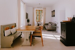 A living room with a wooden table, a sofa, a lamp, and a cabinet. - Hacienda Clavero One Garden Apartment (Málaga)
