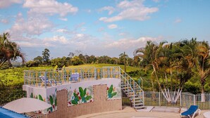 Una terraza con escaleras, asientos al aire libre y vistas a un paisaje verde.