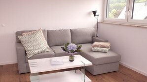 Una sala de estar moderna con un sofá seccional gris, una mesa de centro blanca y una lámpara de pie.