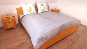 Un dormitorio con una cama, dos mesitas de noche y un tocador.