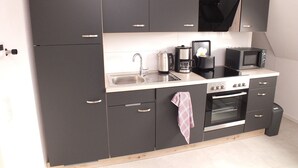 Una cocina moderna con horno integrado, cafetera y microondas.