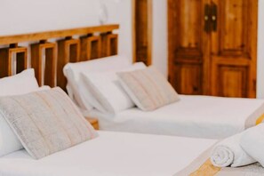 A hotel room with two beds, wooden headboards, and a wooden wardrobe. - Hacienda Clavero Four Garden Apartment: (Málaga)