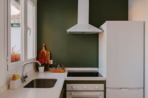 Eine Küche mit einem weißen Herd, einer Spüle und einem weißen Kühlschrank.