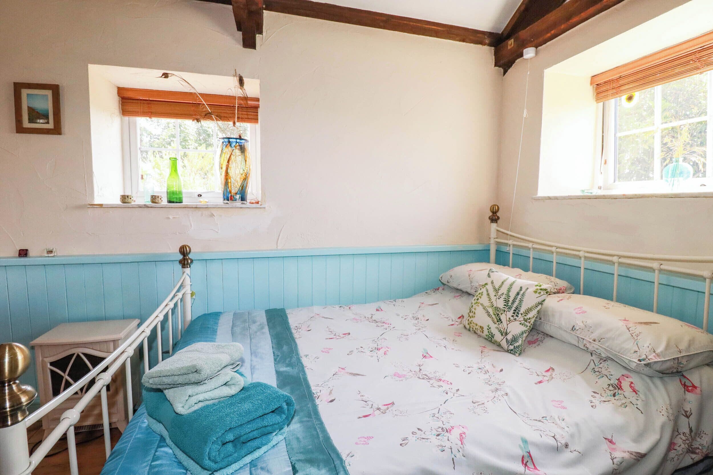 Un dormitorio con una cama individual, una ventana con vistas y una mesita de noche.