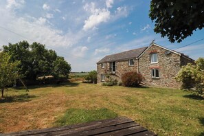 A stone house with a grassy yard and trees. - The Granary (Truro)