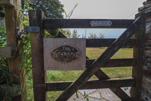 Ein rustikales Holztor mit einem Schild, auf dem 'The Grange' steht.