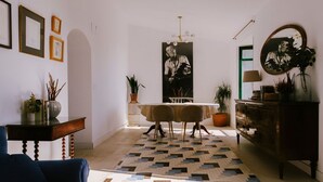 A dining area with a table and chairs, a patterned floor, and framed pictures on the walls. - Hacienda Clavero Seven Deluxe Apartment: (Málaga)