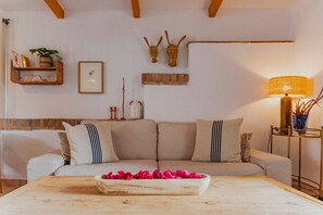 Ein gemütliches Wohnzimmer mit einer Couch, einem Holztisch und einer Lampe.
