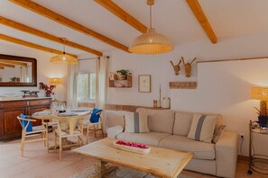 Ein gemütliches Wohnzimmer mit einem Holzesstisch, einer Couch und einem Couchtisch.