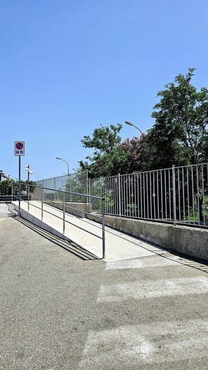 Un ciel dégagé, une clôture en métal et un panneau indiquant qu’il est interdit de se garer.