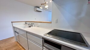 A modern kitchen with a built-in stove, a sink, and a wooden countertop.