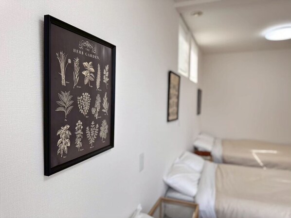 A hotel room with a framed botanical print on the wall, a bed, and a bedside table.