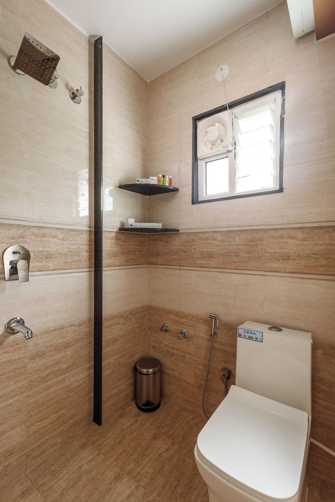 Un baño con inodoro, ducha y ventana.