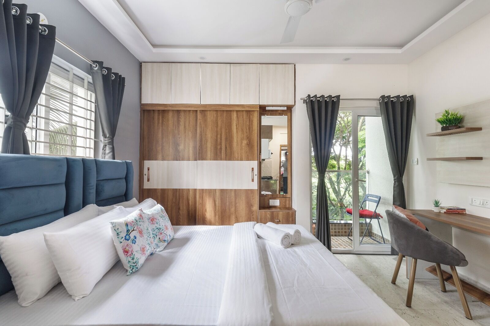 A bedroom with a bed, a desk, a chair, and a wardrobe.