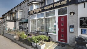 A hotel named 'EVON GUEST HOUSE' with a red door, a signboard, and a welcome mat. - Devon Guest House (Blackpool)