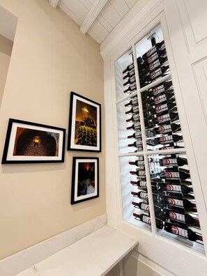 A room with a wine rack filled with bottles, a bench, and three framed pictures on the wall. - Preacher's Yard Stylish Central York Apartment - Duplex 3 (York)