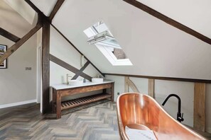 A modern bathroom with a skylight, wooden beams, and a herringbone floor pattern. - Preacher's Yard Stylish Central York Apartment - Duplex 3 (York)