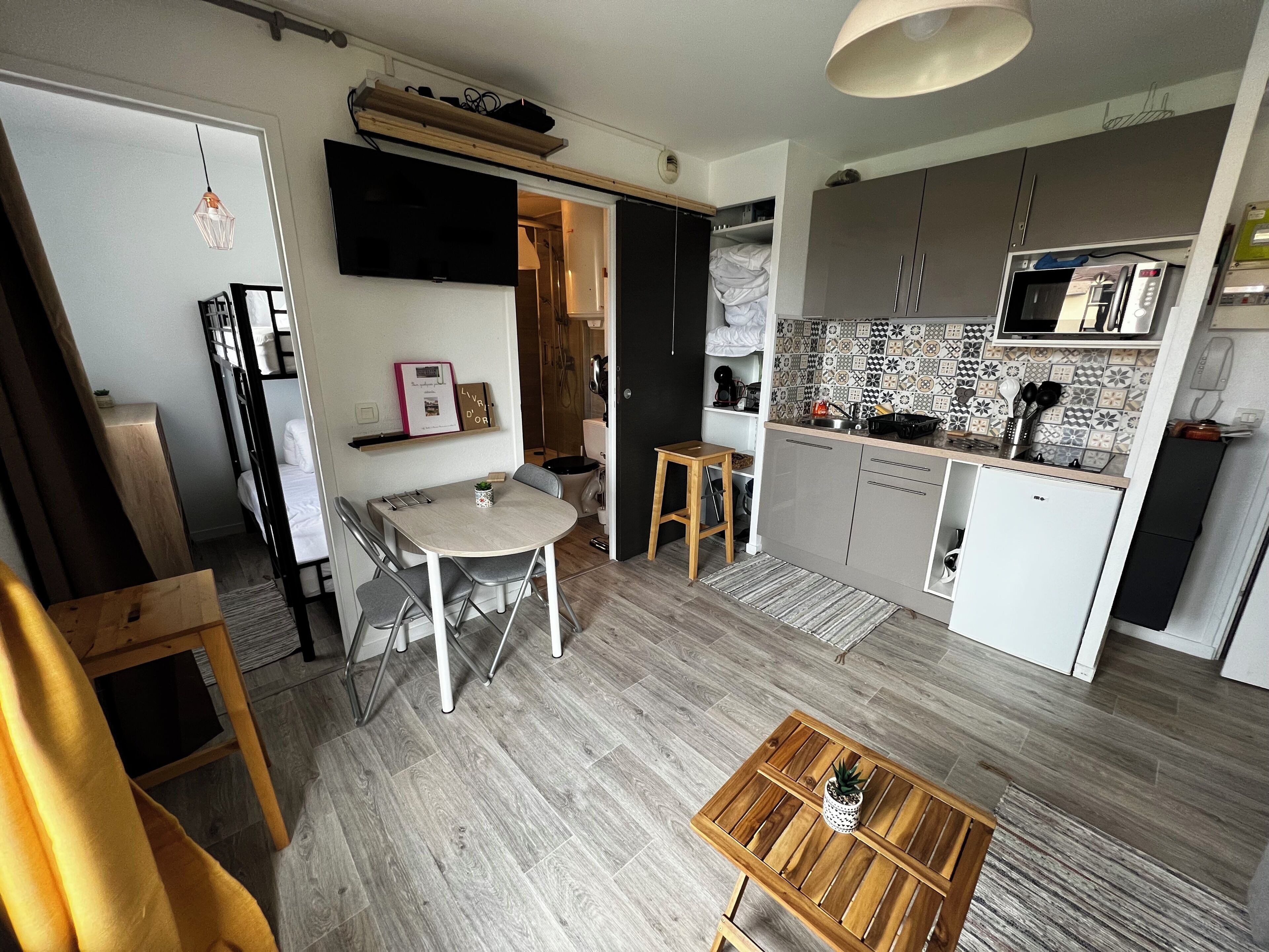 Una cucina compatta con forno a microonde, fornelli e pensili.