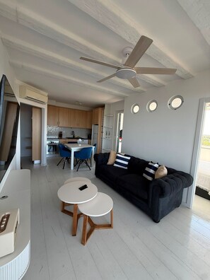 A modern living space with a dining area, kitchen, and a ceiling fan. - Reformed Vintage Top Floor Stunning Views by Bento Box (Quarteira)