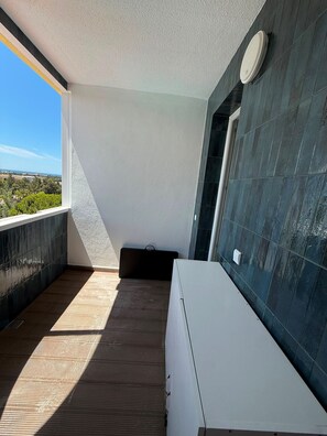 A balcony with a view of the landscape, a white bathtub, and a dark tiled wall. - Reformed Vintage Top Floor Stunning Views by Bento Box (Quarteira)