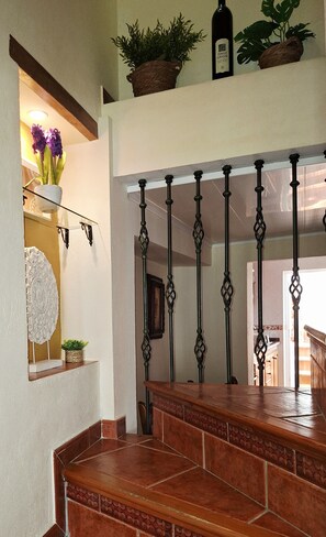 A staircase with a decorative railing, a potted plant, and a bottle on the landing. - Casa Luciíta: Cozy, with a fireplace, patio, and BBQ. Near Marbella (Ojén)