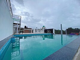 Una piscina en la azotea con vistas despejadas al cielo y edificios circundantes.