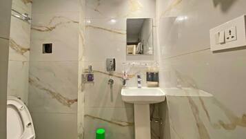 Un baño con inodoro, lavamanos y ducha.