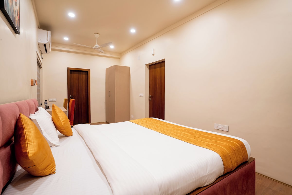 Habitación de hotel con cama, escritorio, silla y armario.