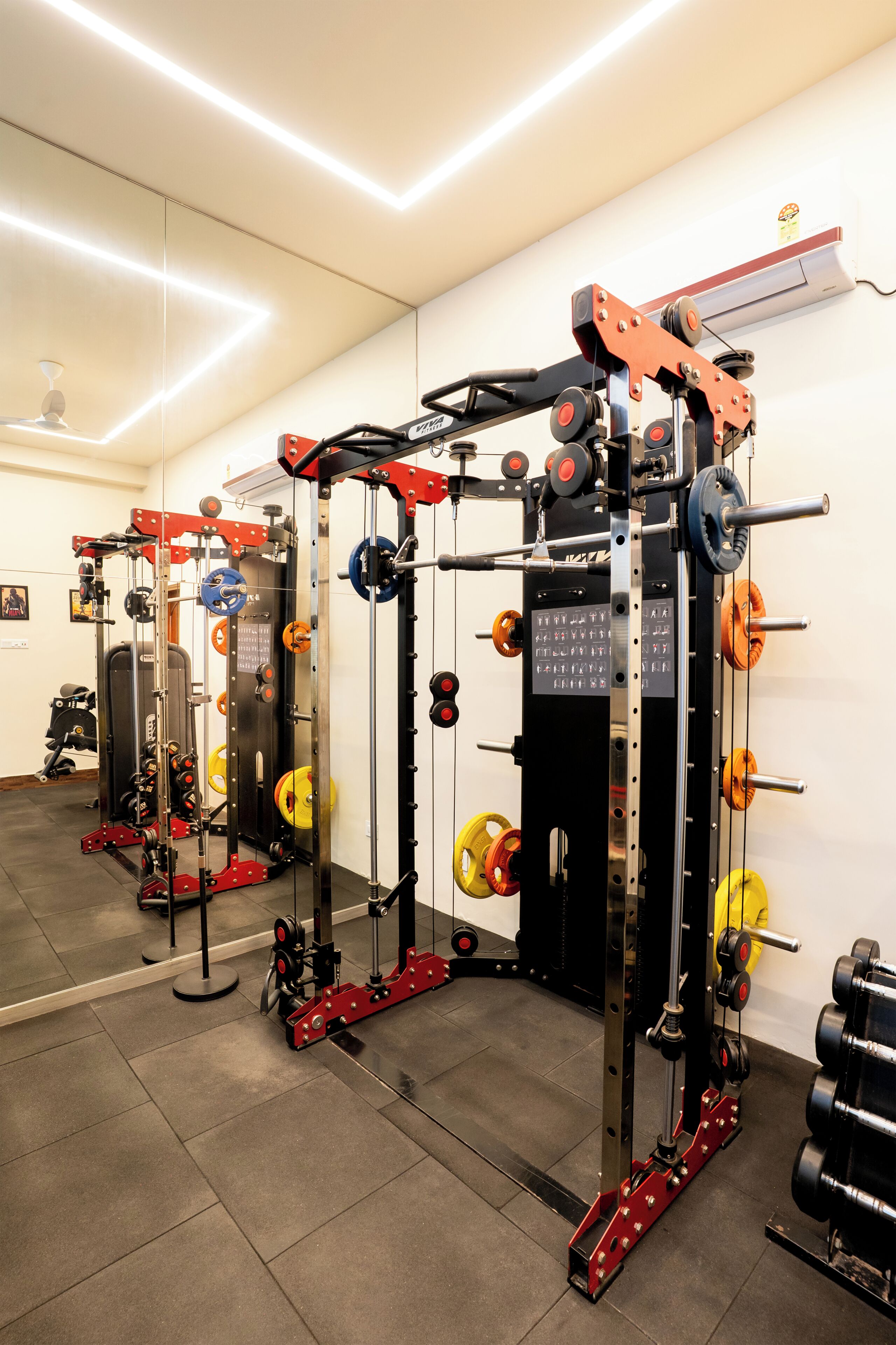 Un gimnasio con diverso equipo de levantamiento de pesas, incluyendo un rack de sentadilla y barras.