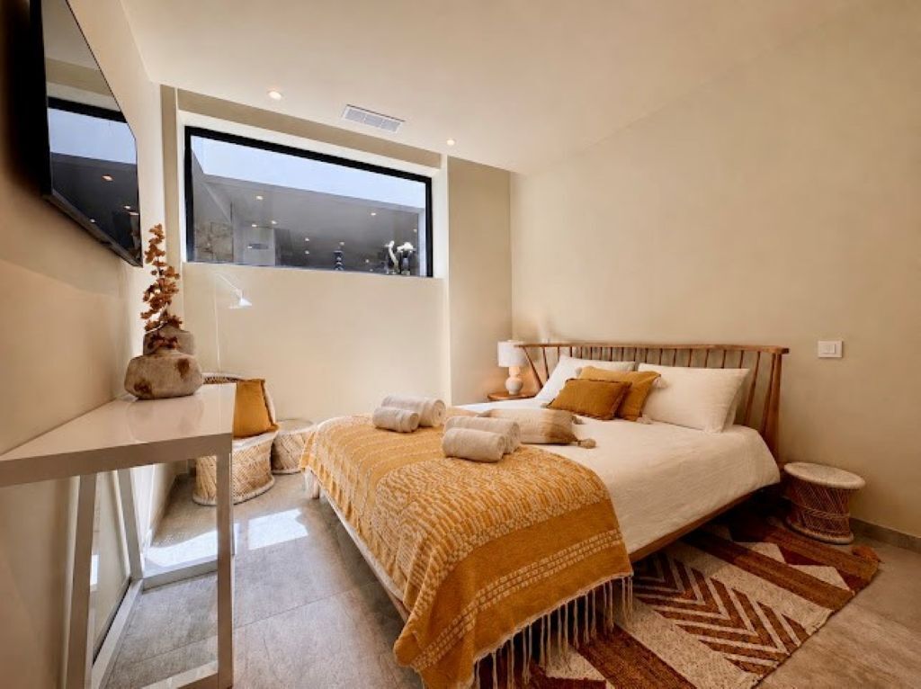 Une chambre moderne avec un lit, une table de chevet et une fenêtre.