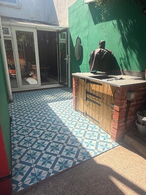 A tiled patio area with a wooden counter and a green wall. - Hens/Stags | Families | Corp | 14 guests £39pp (Cardiff)